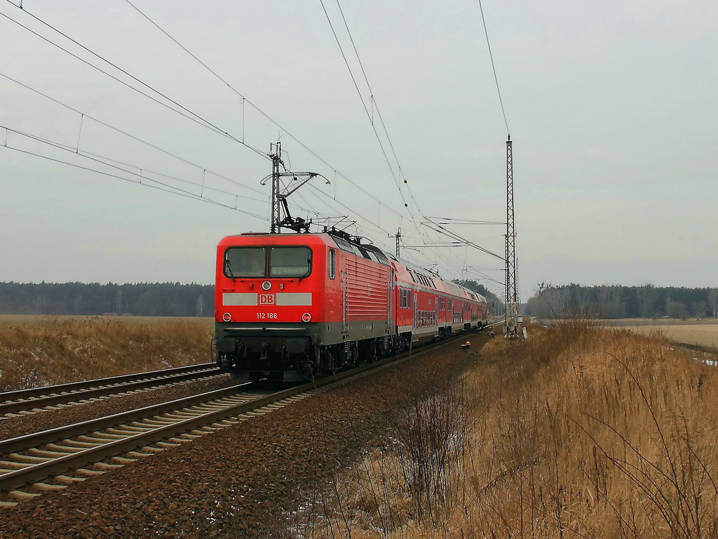 Schublok 112 186 mit dem RE 3 nach Stralsund am 07. Februar 2012 nach dem passieren des Bahnbergang ber die Bundesstrasse 96 / 115 in Golen in Richtung Berlin. 