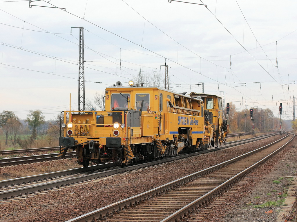 Bahnhof Saarmund am 10. November 2012, Durchfahrt Gleisstopfmaschine 09-32 CSM der Firma Spitzke.