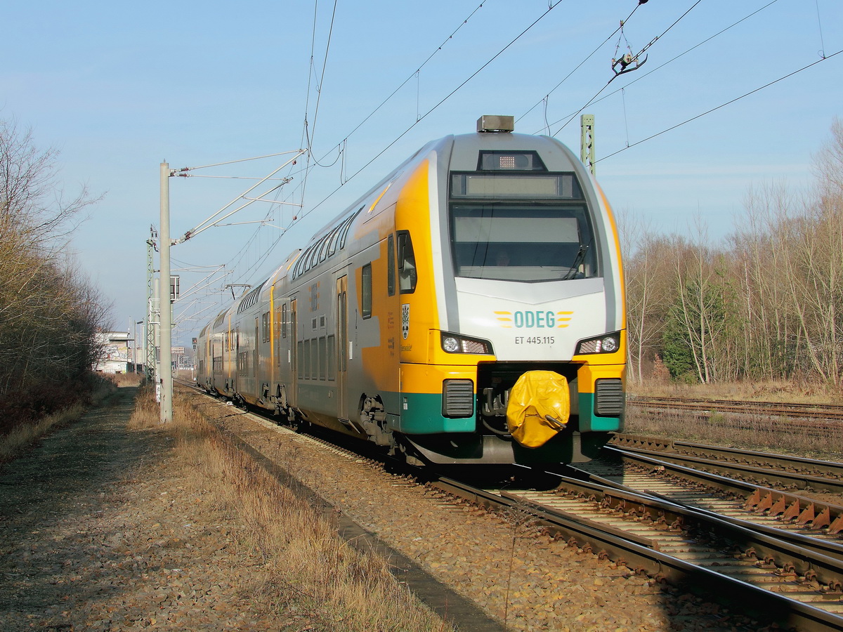 Königs Wusterhausen am 18. Januar 2014, soeben hat ET 445.115 als RE 83966 nach Cottbus den Bahnhof verlassen und den ersten Bahnübergang passiert.